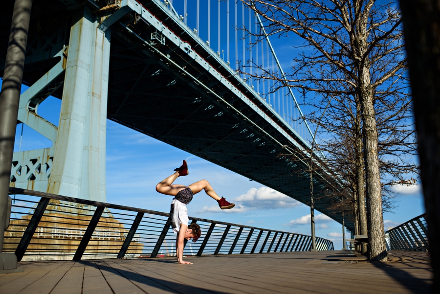 A woman doing a handstand on the boardwalk of race street pier in philadelphia.